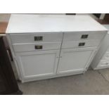 A WHITE CABINET WITH TWO DOORS AND FOUR DRAWERS WITH CAMPAIGN STYLE HANDLES