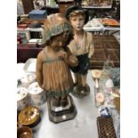 A PAIR OF VINTAGE RESIN FIGURES - WHISTLING BOY AND SHY GIRL