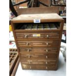 A VINTAGE TABLE TOP WOODEN CHEST OF DRAWERS (ONE DRAWER MISSING)