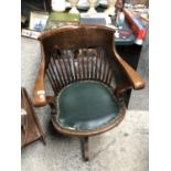 A WOODEN CAPTAINS CHAIR WITH LEATHER SEAT ON A SWIVEL BASE