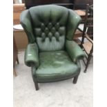 A GREEN LEATHER WING AND BUTTON BACK ARMCHAIR