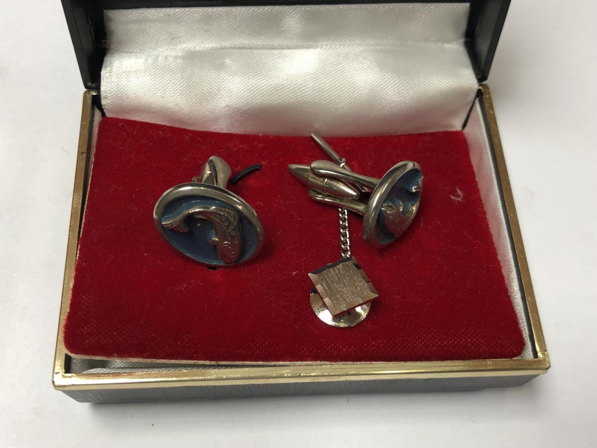 A SET OF METAL CUFFLINKS WITH SALMON MOTIFS AND A METAL TIE PIN