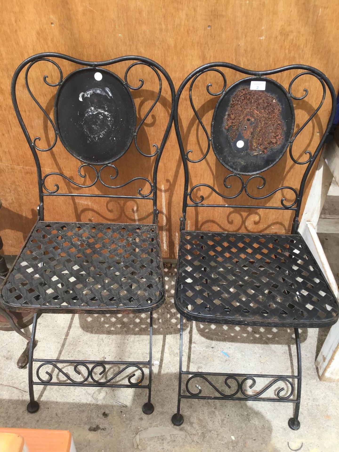 A PAIR OF METAL FOLDING BISTRO STYLE CHAIRS