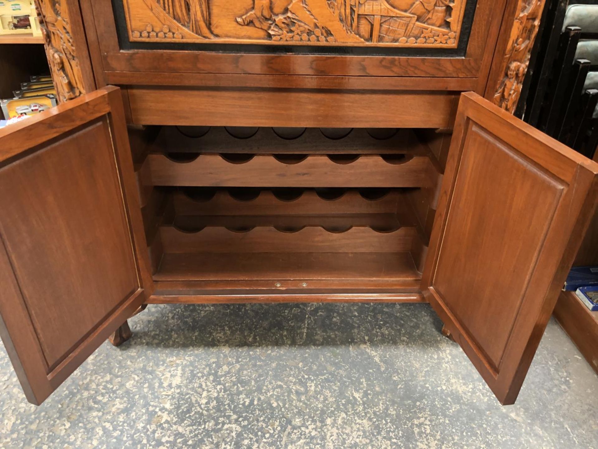 A LARGE CARVED WOODEN ORIENTAL DRINKS CABINET WITH LOWER DOORS REVEALING WINE RACK, UPPER MIRRORED - Image 4 of 6