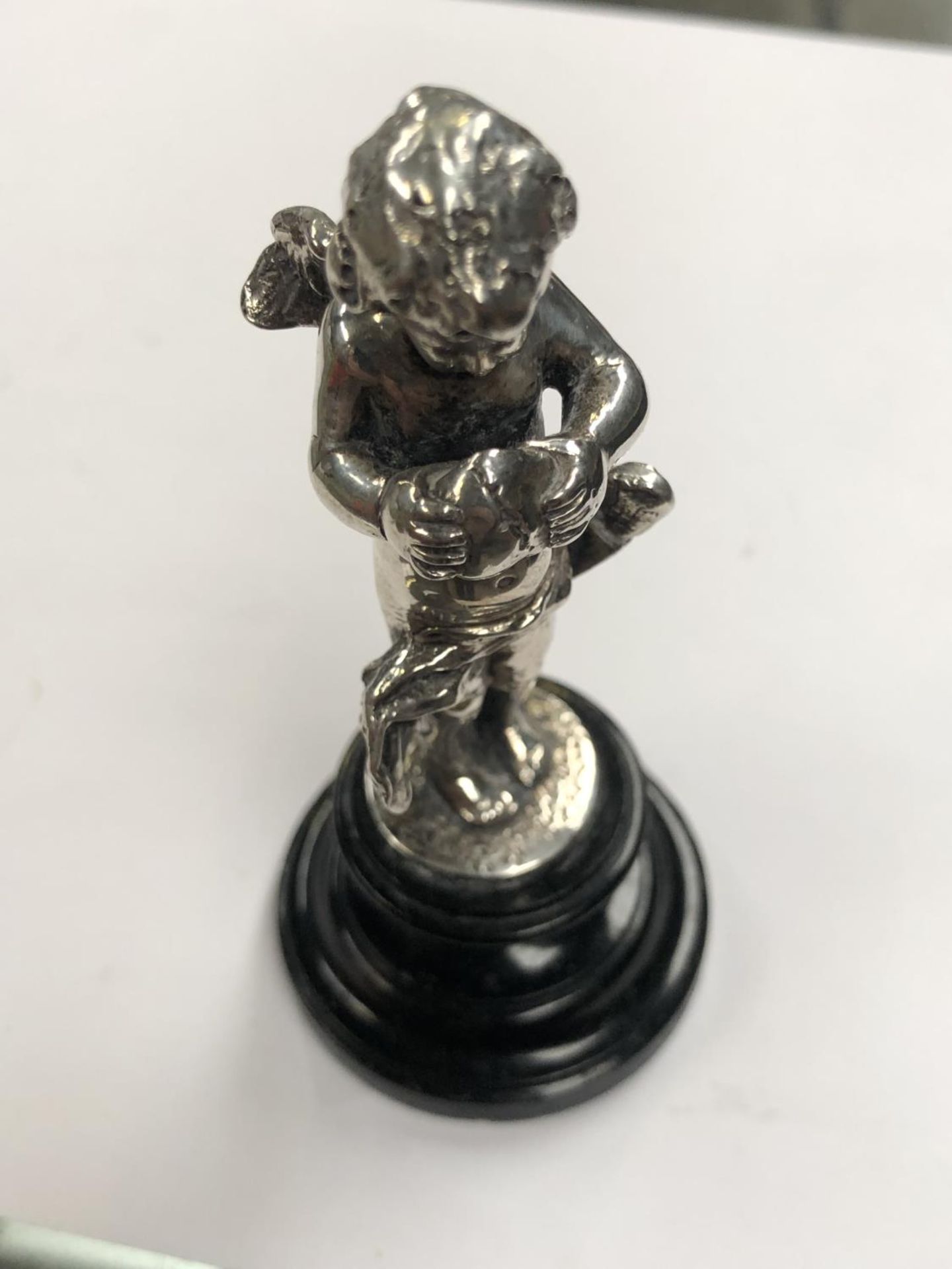 A SMALL SILVER CONTINENTAL .800 CHERUB ON BASE