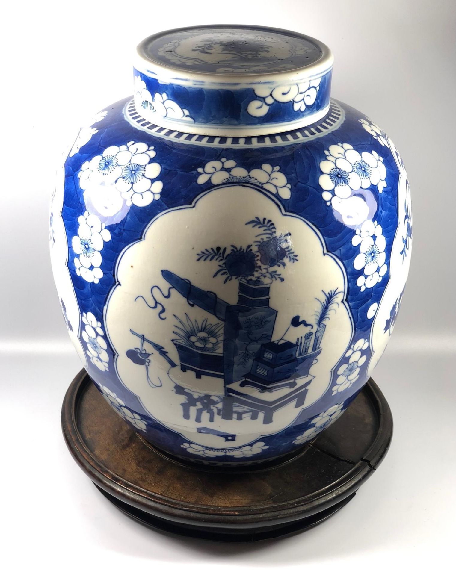 A LARGE CHINESE 19TH CENTURY BLUE AND WHIE PRUNUS OBJECTS PATTERN GINGER JAR ON CARVED ORIENTAL