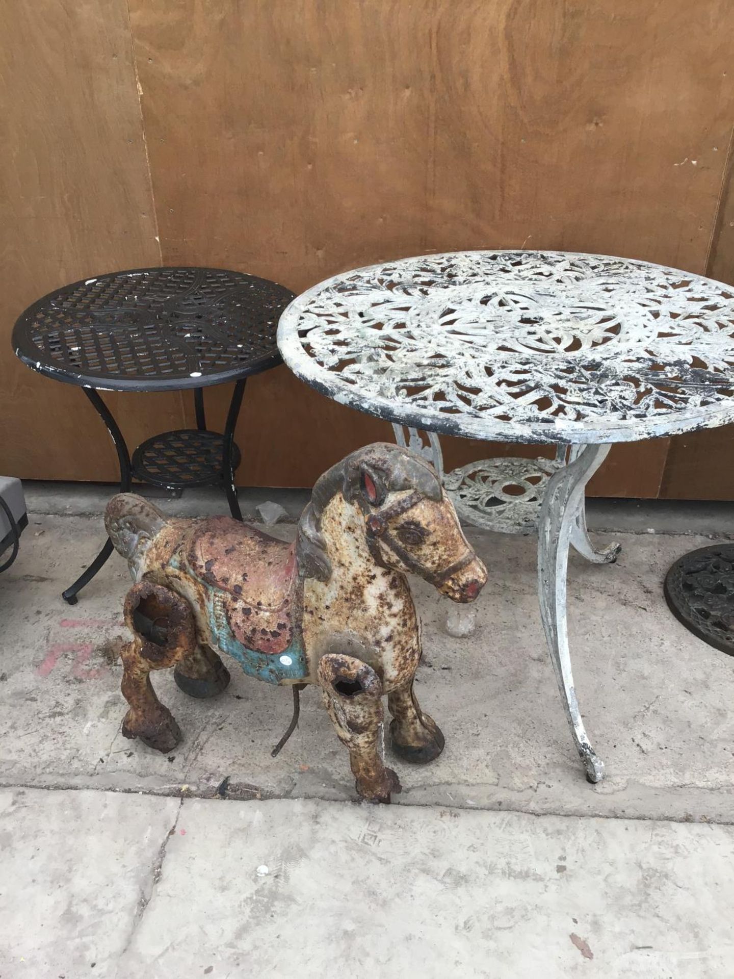 TWO CAST IRON PATIO TABLES (60CM AND 90CM DIAMETER) AND A VINTAGE FAIRGROUND HORSE