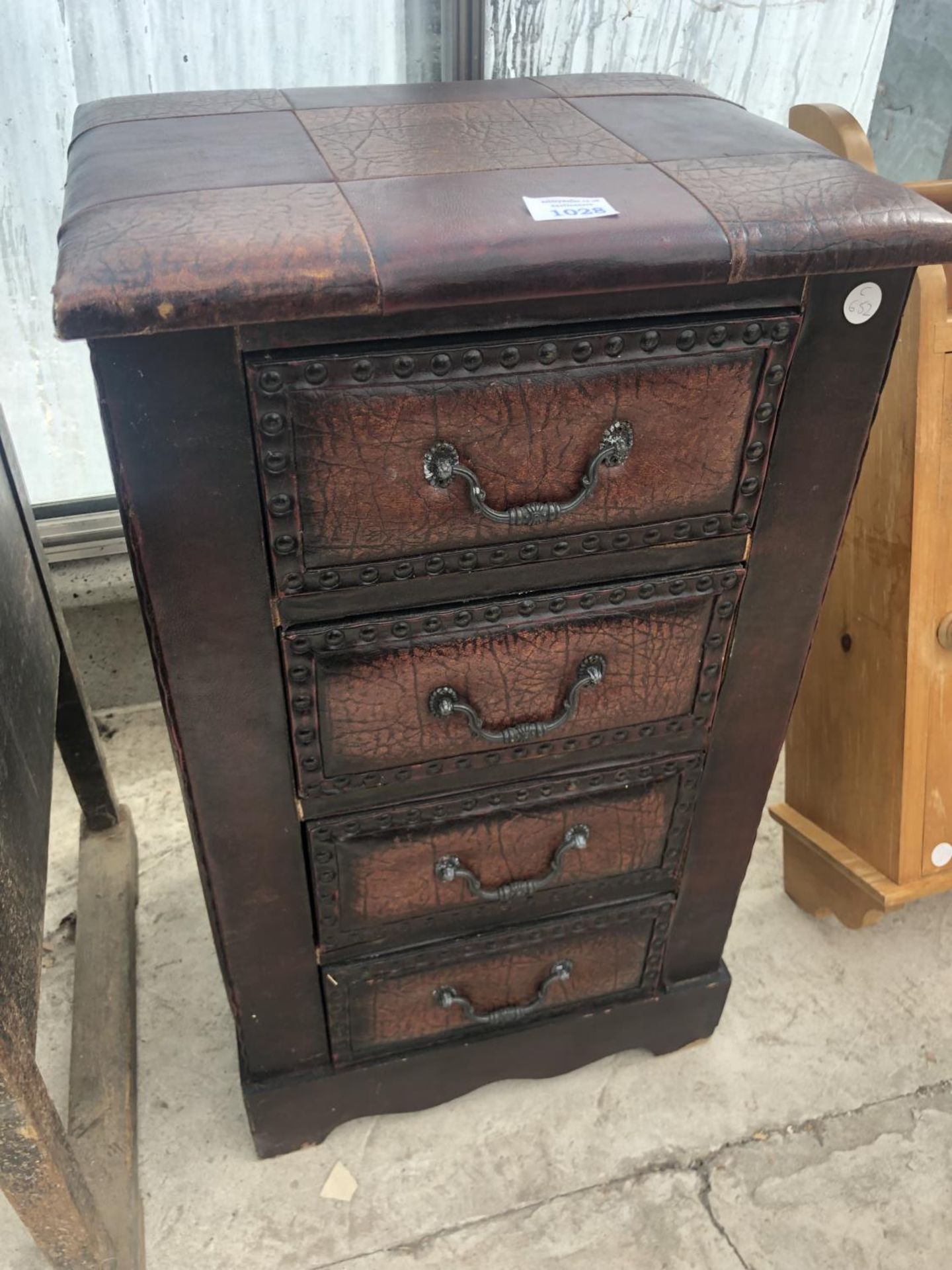 A LEATHER UPHOLSTERED SMALL CHEST OF FOUR DRAWERS