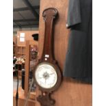 A WOODEN CASED BAROMETER WITH TURNED DESIGN