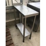 A STAINLESS STEEL TROLLEY TABLE ON WHEELS 32CM X 73CM X 95CM HIGH