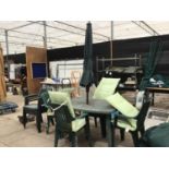 A GREEN PLASTIC GARDEN TABLE WITH FOUR CHAIRS, SEAT PADS AND PARASOL