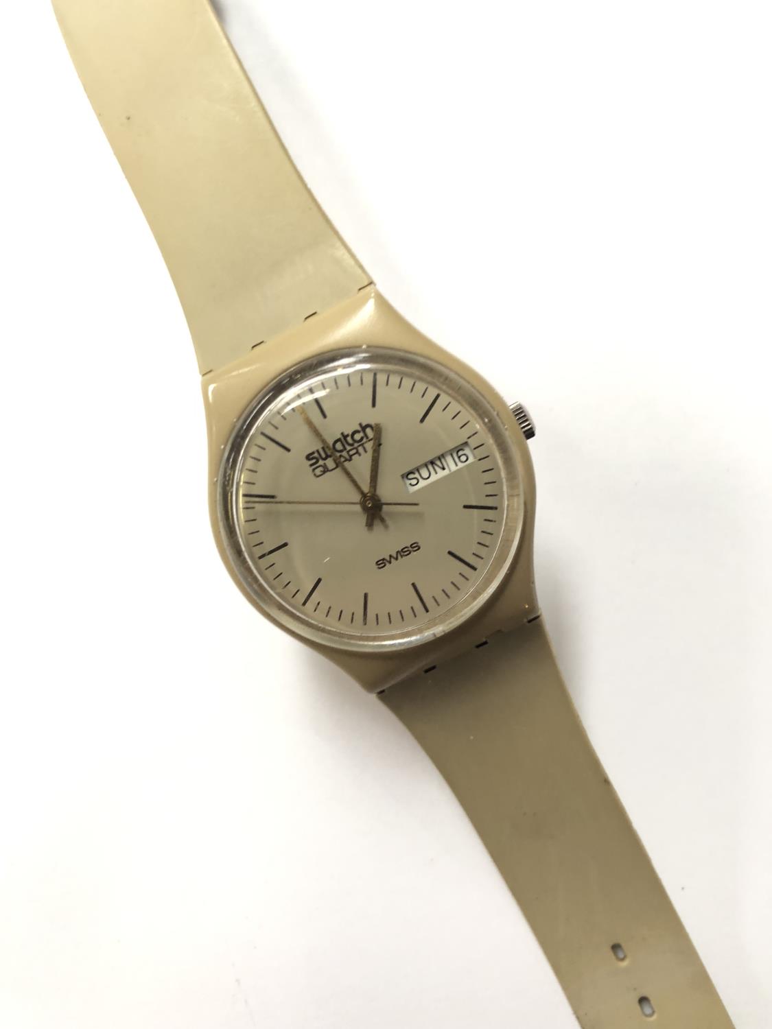 A GENTS SWATCH WATCH WITH DAY DATE FEATURE