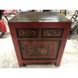 AN ORIENTAL RED LACQUERED CABINET WITH TWO DRAWERS AND LOWER DOOR