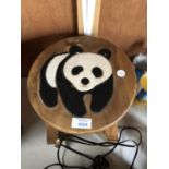 A SMALL WOODEN STOOL WITH PANDA DESIGN