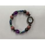 A SILVER LADIES WATCH ON GEMSTONE BRACELET/STRAP