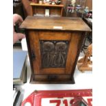 AN ARTS AND CRAFTS OAK SMOKERS CABINET WITH METAL DESIGN FRONT PANEL