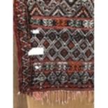 A LARGE PATTERNED TASSEL RUG 260CM X 140CM APPROX