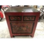 AN ORIENTAL RED LACQUERED CABINET WITH TWO DRAWERS AND LOWER DOOR