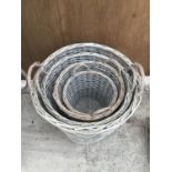 A SET OF FOUR ROUND WICKER BASKETS