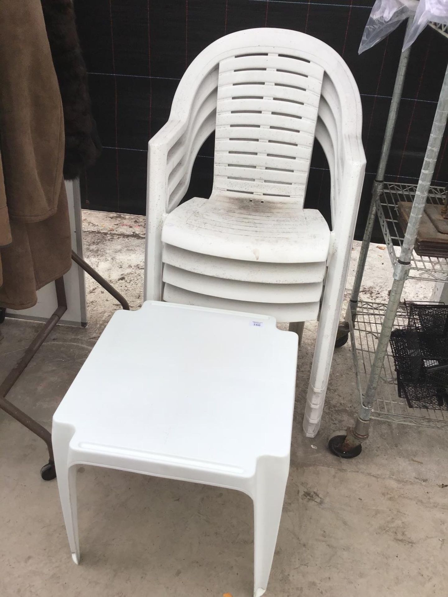 FOUR WHITE PLASTIC GARDEN CHAIRS AND A SQUARE TABLE