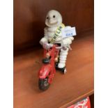 A CAST MICHELIN MAN ON RACING BIKE MODEL