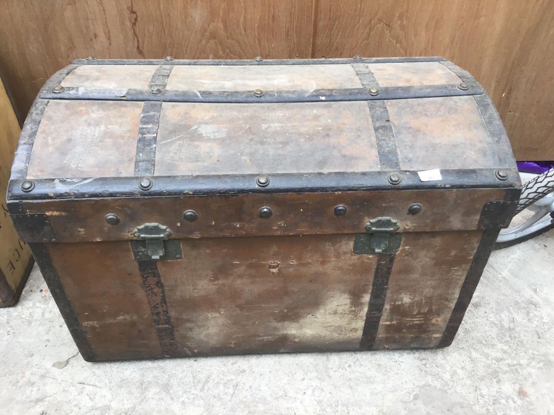 A VINTAGE WOODEN TRUNK WITH METAL STRAPPING (HANDLES A/F)