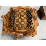 AN INDIAN CHESS SET, BOARD MADE FROM A TREE TRUNK WITH METAL PIECES