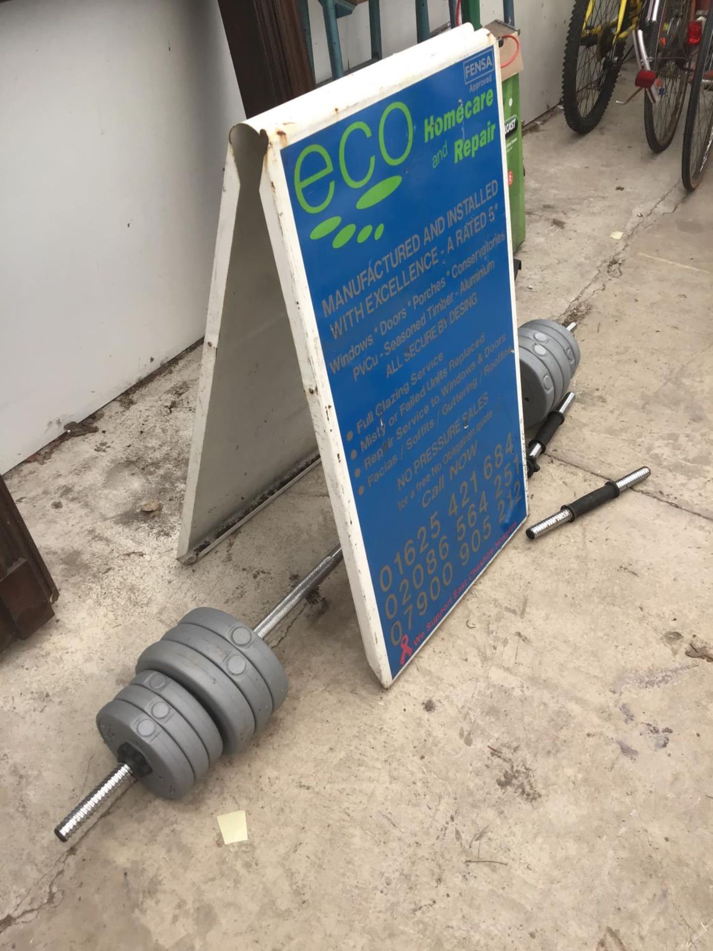 A METAL A FRAME ADVERTISING BOARDS AND A WEIGHT LIFTING BAR WITH WEIGHTS