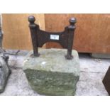 A VINTAGE BOOT SCRAPER SET IN A STONE BLOCK