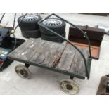 A VINTAGE FOUR WHEELED WOODEN TRUCK WITH METAL WHEELS