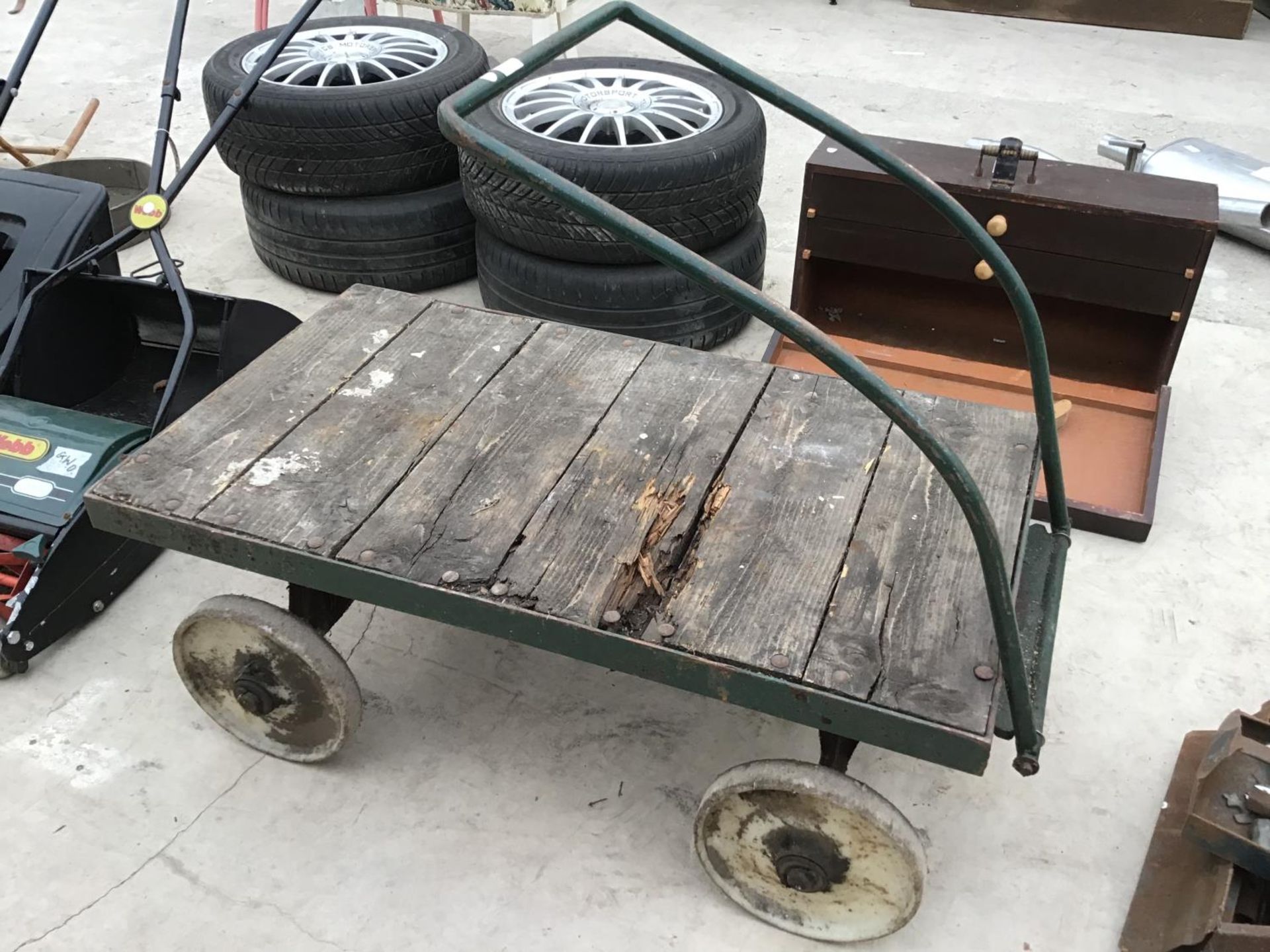 A VINTAGE FOUR WHEELED WOODEN TRUCK WITH METAL WHEELS