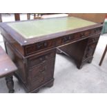 A GREEN LEATHER TOPPED TWIN PEDESTAL DESK