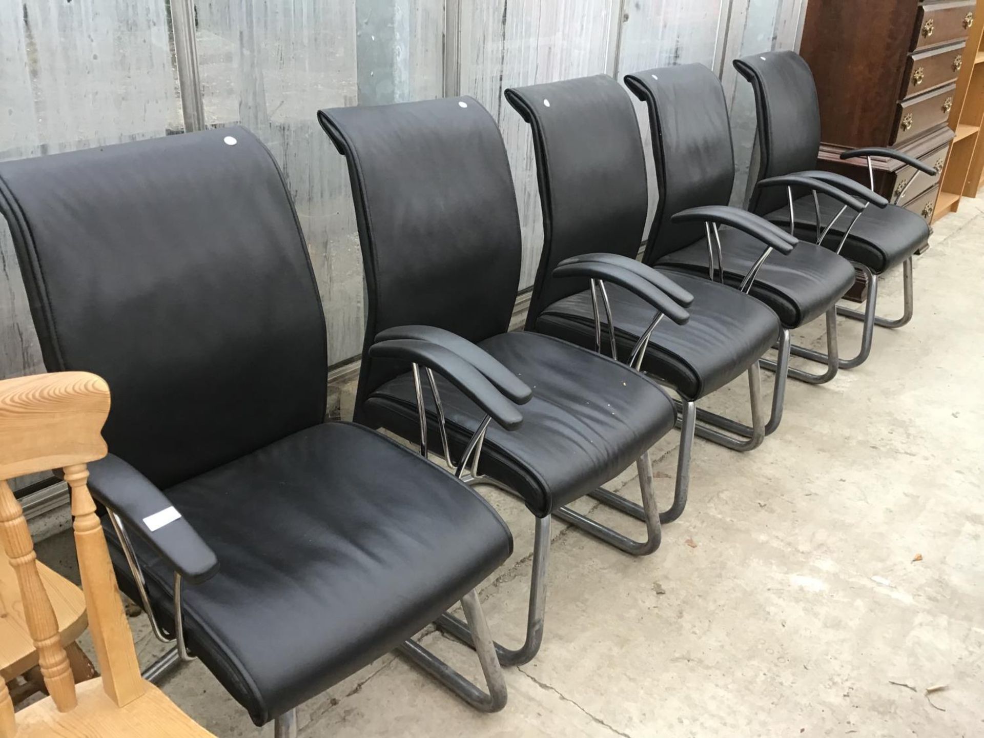 A SET OF FIVE BLACK LEATHERETTE WAITING ROOM ARMCHAIRS