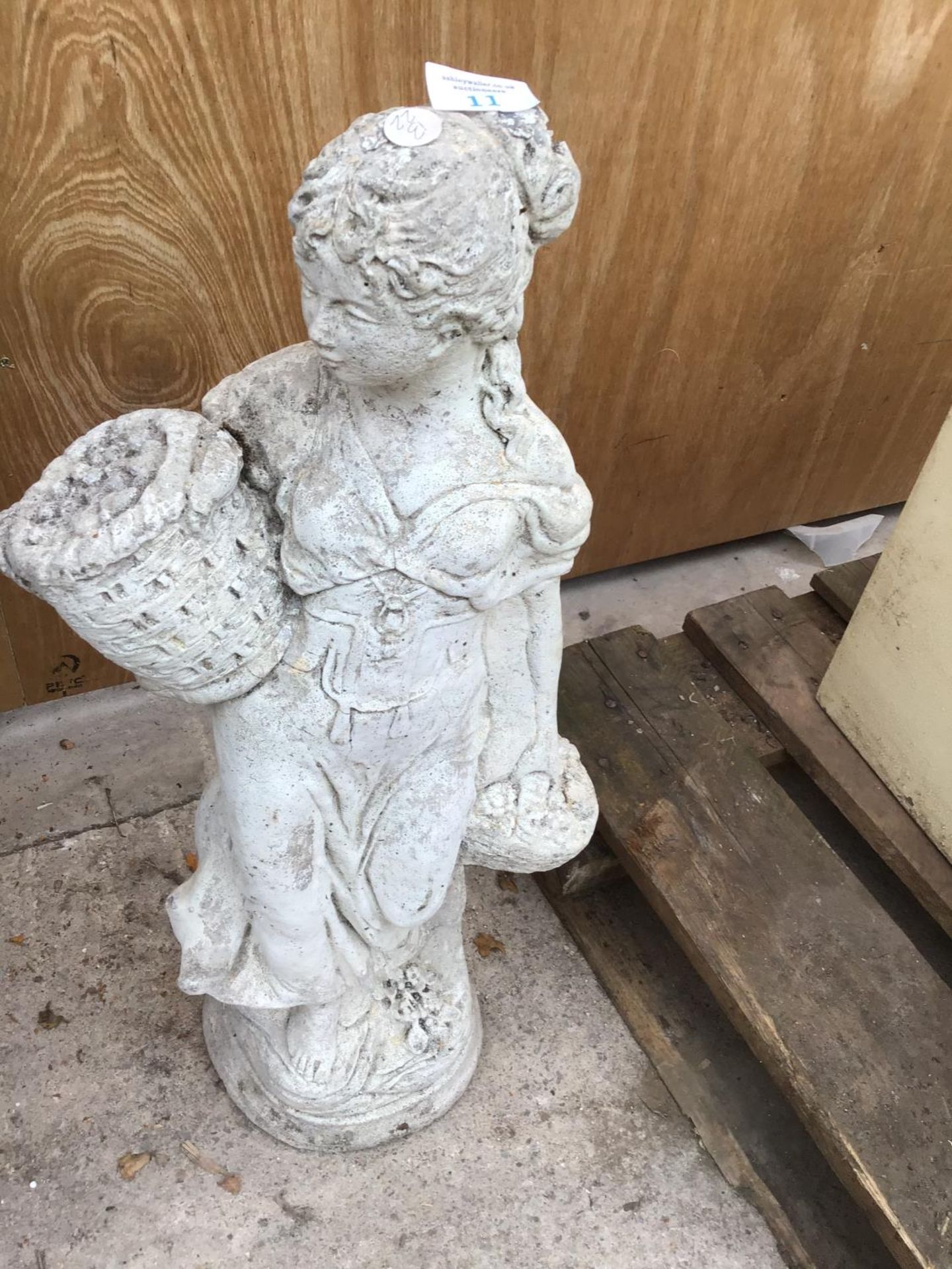 A CONCRETE GARDEN ORNAMENT OF A GIRL WITH A BASKET