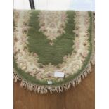 A GREEN PATTERNED OVAL RUG 144CM X 96CM