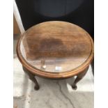 A CIRCULAR GLASS TOPPED COFFEE TABLE