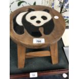 A SMALL WOODEN STOOL WITH PANDA DESIGN