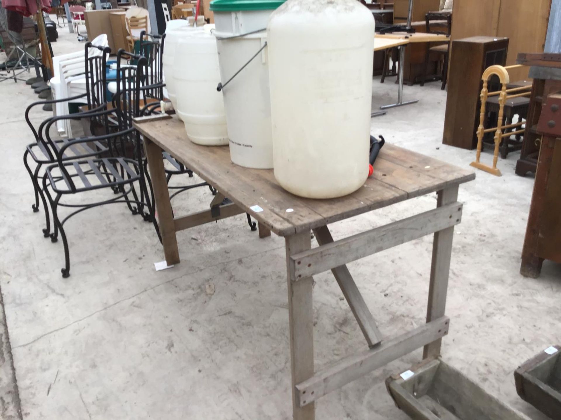 A VINTAGE WOODEN TRESTLE TABLE WITH VARIOUS PLASTIC BREWING BUCKETS AND BARRELS