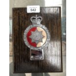 A CHESHIRE REGIMENT CAR MASCOT ON WOODEN PLAQUE