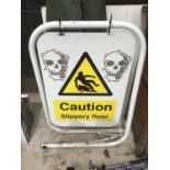 A LARGE SIGN SHOWING CAUTION SLIPPERY FLOOR