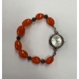 A LADIES WRIST WATCH ON AMBER STYLE BRACELET