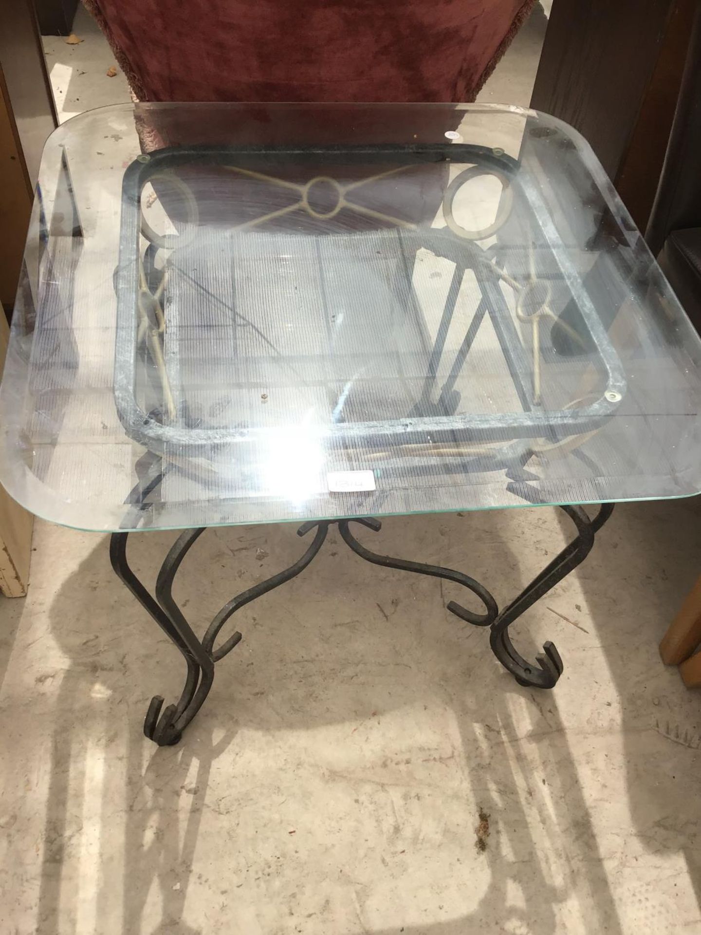 A GLASS TOPPED COFFEE TABLE WITH METAL BASE