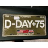 A METAL D-DAY LICENSE PLATE SIGN