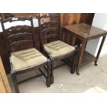 AN OAK TEA TROLLEY AND TWO LADDER BACK DINING CHAIRS