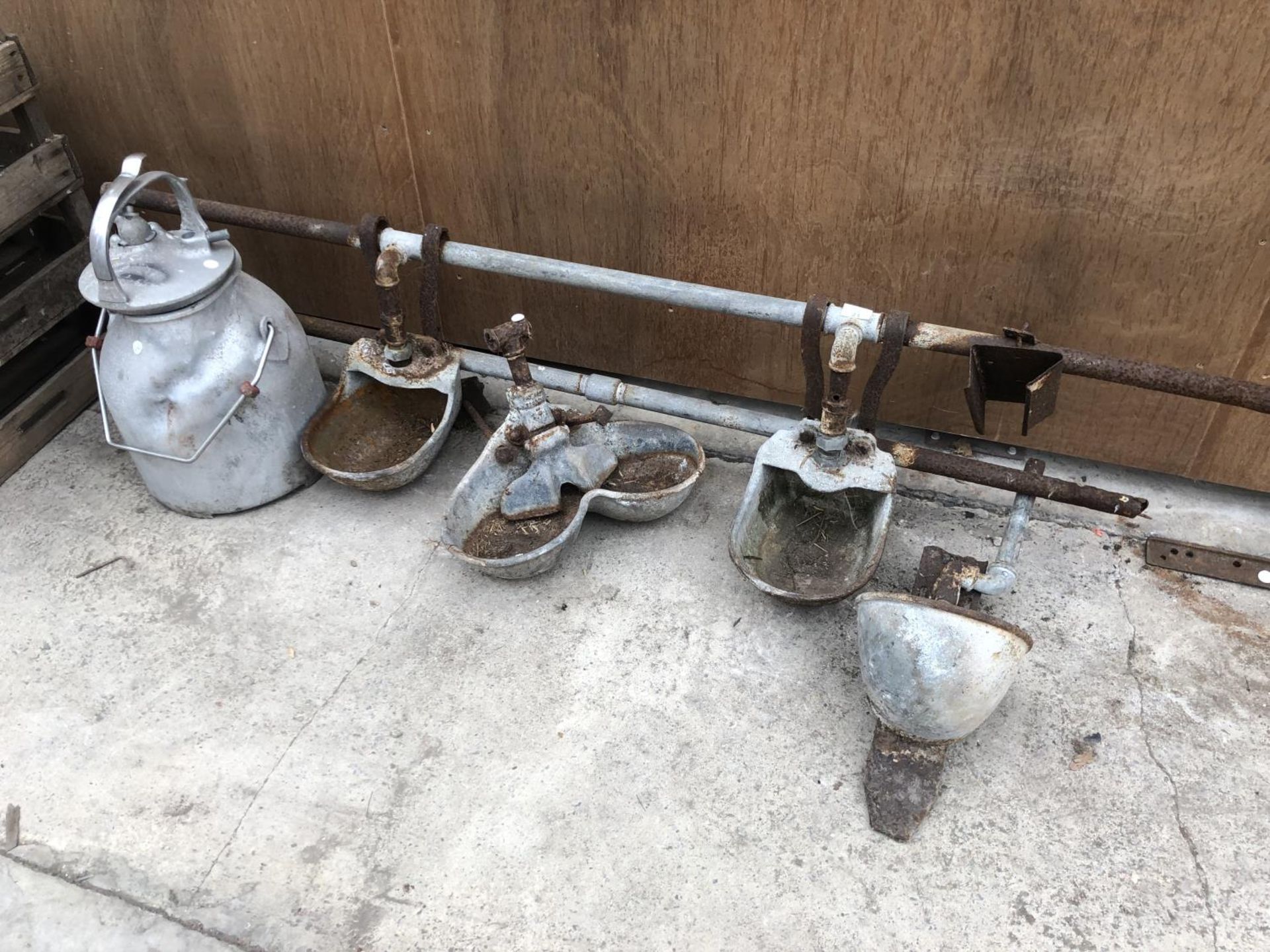 FOUR VARIOUS CALF DRINKERS WITH PIPE AND A GALVANISED MILKING BUCKET