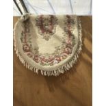 A CREAM AND FLORAL OVAL RUG WITH TASSEL EDGING