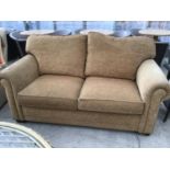 A MODERN CREAM UPHOLSTERED TWO SEATER SOFA