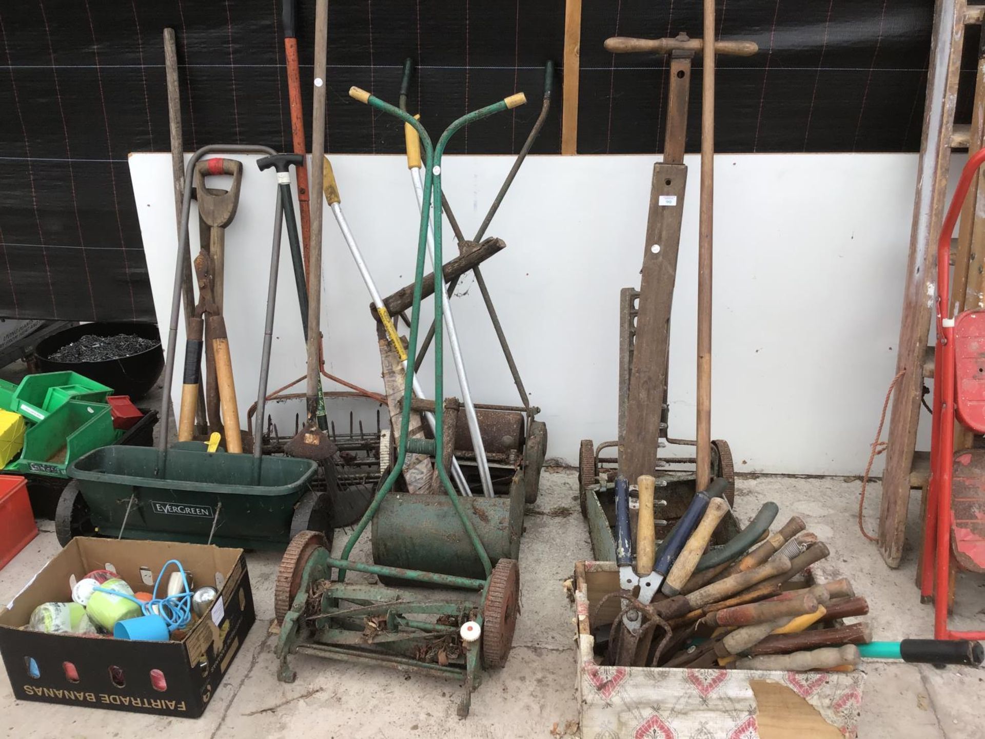 A LARGE COLLECTION OF VINTAGE GARDENING TOOLS TO INCLUDE SHEARS, MOWERS, SPADES ETC