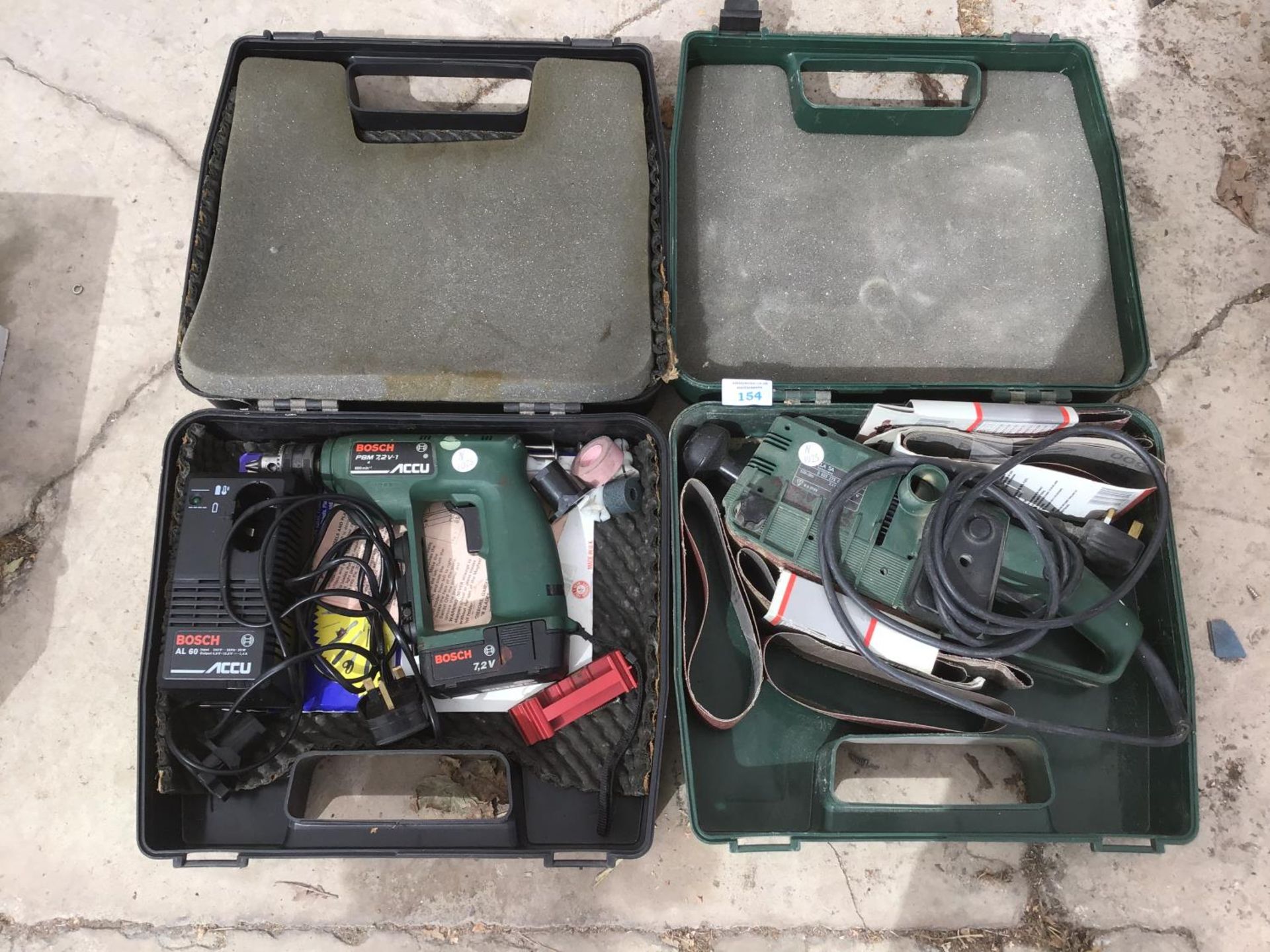 A BOSCH BELT SANDER IN A CASE AND A BOSCH PBM 7-2V-1 CORDLESS DRILL IN CASE WITH BATTERY AND CHARGER
