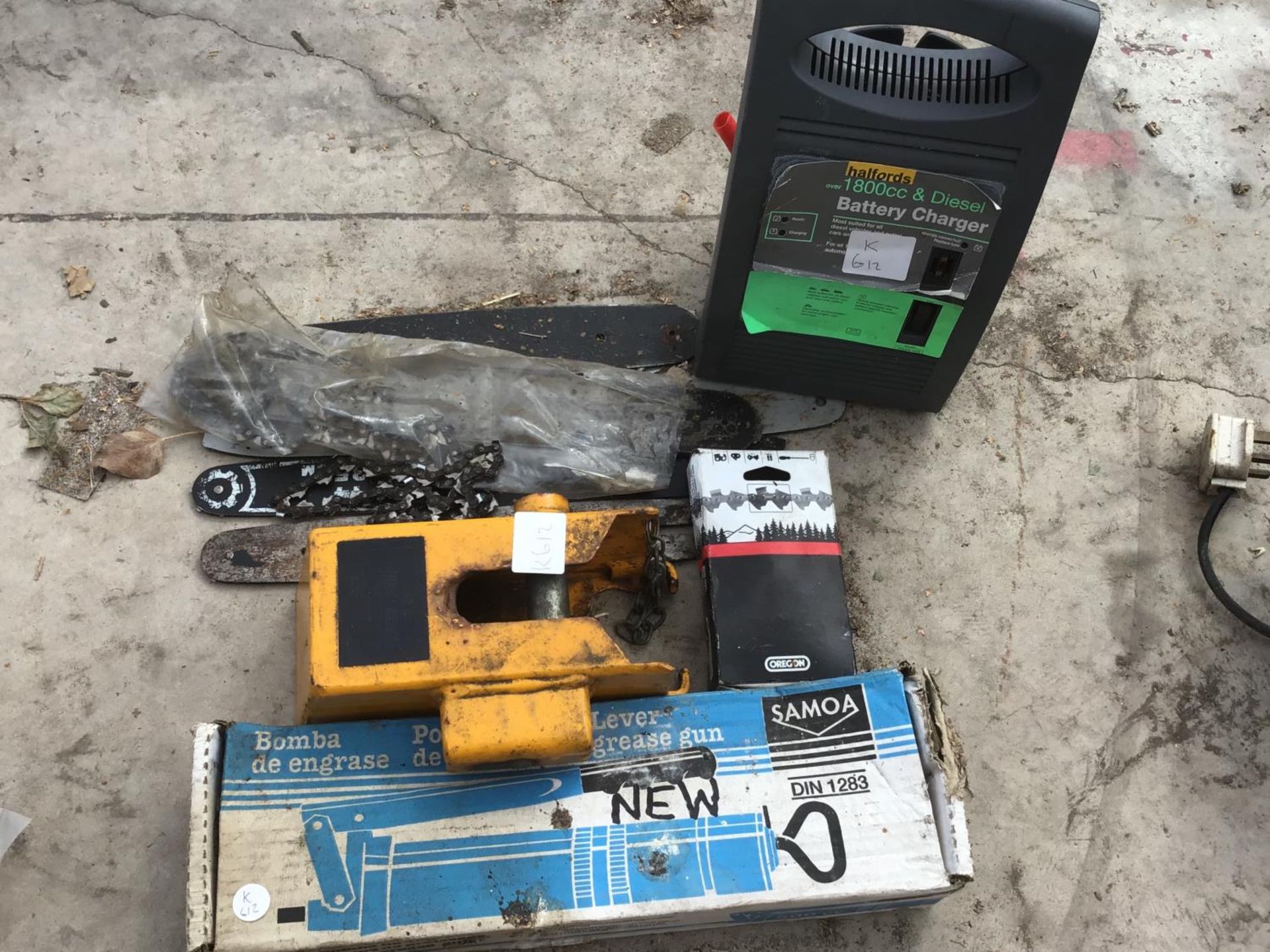 A GREASE GUN, BATTERY CHARGER IN WORKING ORDER, CHAINSAW BLADES AND CHAINS ETC